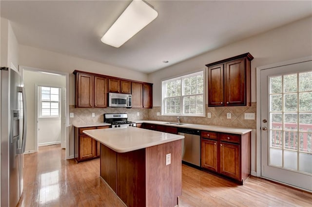 kitchen featuring appliances with stainless steel finishes, a wealth of natural light, and a kitchen island