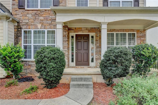 view of exterior entry featuring covered porch