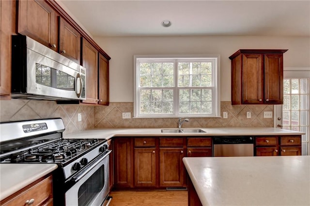 kitchen featuring light hardwood / wood-style floors, tasteful backsplash, appliances with stainless steel finishes, and sink