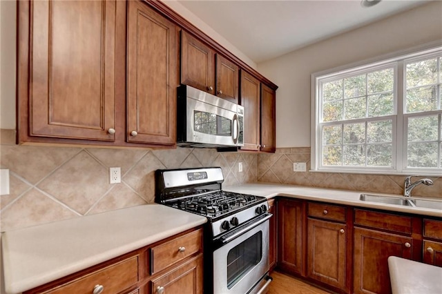 kitchen with appliances with stainless steel finishes, sink, and backsplash