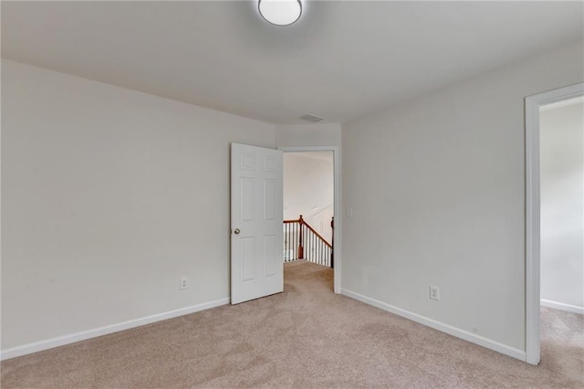 unfurnished room featuring light colored carpet