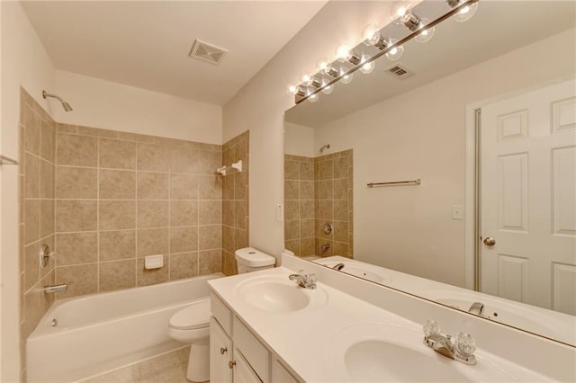 full bathroom with toilet, tiled shower / bath combo, vanity, and tile patterned flooring