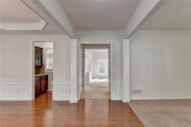 hallway featuring ornate columns and wood-type flooring