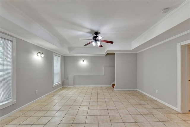 tiled spare room featuring ornamental molding, a tray ceiling, and ceiling fan