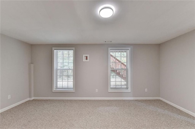 unfurnished room with carpet flooring and plenty of natural light