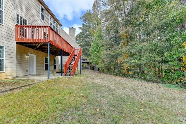 view of yard featuring a wooden deck and a patio area