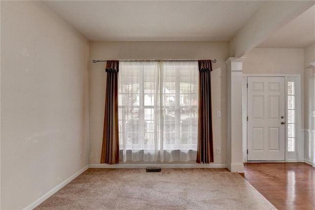 entryway with light hardwood / wood-style flooring and ornate columns