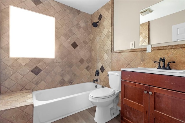 full bathroom featuring tiled shower / bath, wood-type flooring, vanity, decorative backsplash, and toilet