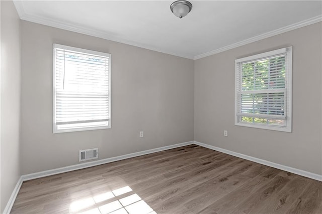 empty room with crown molding and hardwood / wood-style floors