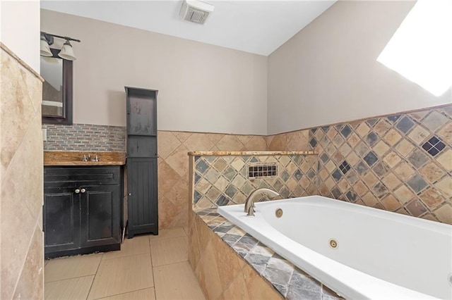 bathroom with vanity, tile walls, tile patterned floors, and a relaxing tiled tub