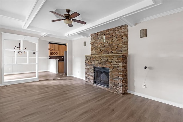 unfurnished living room featuring ceiling fan, a fireplace, wood-type flooring, coffered ceiling, and ornamental molding