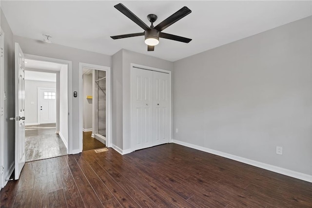 unfurnished bedroom featuring a closet, dark hardwood / wood-style floors, and ceiling fan