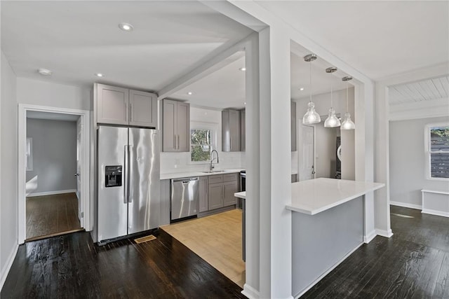 kitchen with stainless steel appliances, dark hardwood / wood-style floors, gray cabinets, and sink