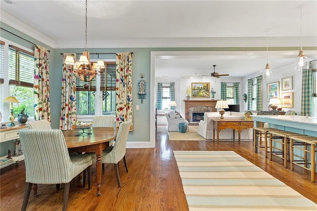 dining room featuring a fireplace, ornamental molding, and plenty of natural light