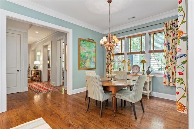 dining room featuring a chandelier, crown molding, and wood-type flooring