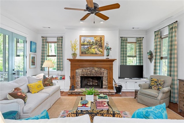 living room with a fireplace, ceiling fan, light hardwood / wood-style floors, and crown molding