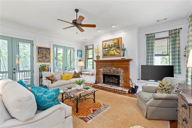 living room with ceiling fan, french doors, crown molding, and a fireplace