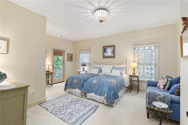 bedroom with light colored carpet, multiple windows, and access to exterior