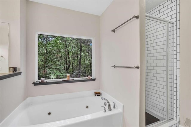full bathroom with a shower stall and a jetted tub