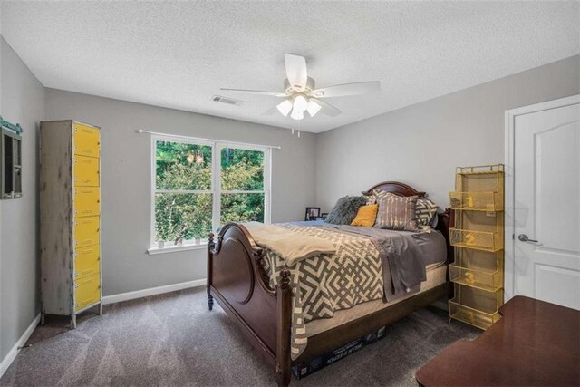 carpeted bedroom featuring a ceiling fan, visible vents, baseboards, and a textured ceiling