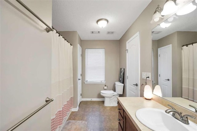 bathroom featuring baseboards, visible vents, toilet, and vanity