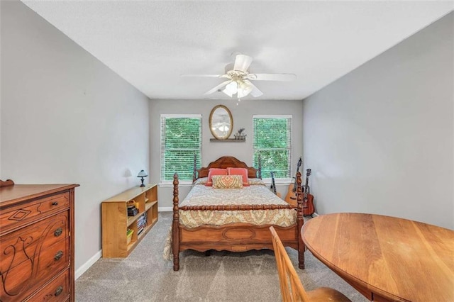 carpeted bedroom featuring baseboards and a ceiling fan