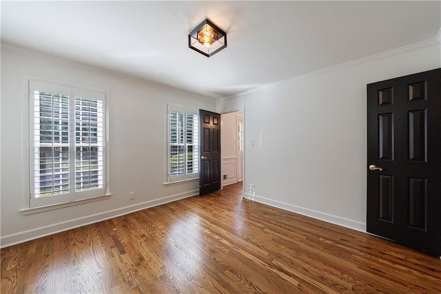 5004 Haralson Way SW, Lilburn, GA 30047 - unfurnished bedroom featuring dark wood finished floors and crown molding