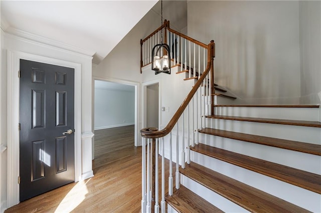 5004 Haralson Way SW, Lilburn, GA 30047 - foyer featuring wood finished floors, a chandelier, stairway, ornamental molding, and lofted ceiling