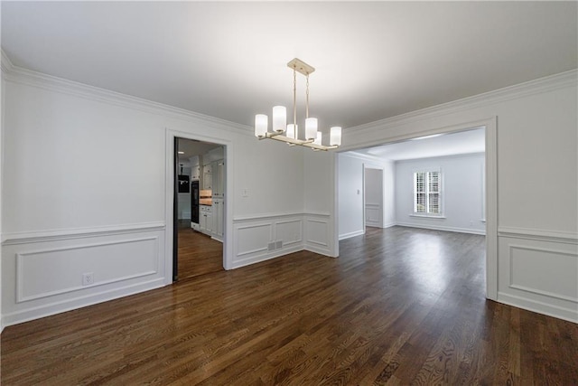 5004 Haralson Way SW, Lilburn, GA 30047 - spare room featuring a chandelier, crown molding, dark wood-style floors, a decorative wall, and a wainscoted wall