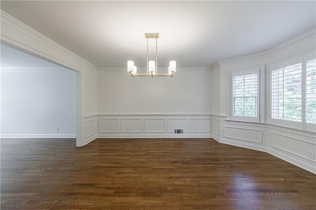 5004 Haralson Way SW, Lilburn, GA 30047 - empty room featuring a chandelier, dark wood-style flooring, crown molding, wainscoting, and a decorative wall