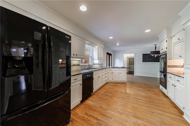 5004 Haralson Way SW, Lilburn, GA 30047 - kitchen featuring black appliances, a peninsula, backsplash, white cabinets, and light wood-type flooring