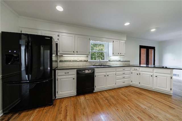 5004 Haralson Way SW, Lilburn, GA 30047 - kitchen with black appliances, a peninsula, ornamental molding, dark countertops, and white cabinets