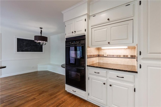 5004 Haralson Way SW, Lilburn, GA 30047 - kitchen with decorative backsplash, white cabinets, a chandelier, dark stone countertops, and dark wood-style floors