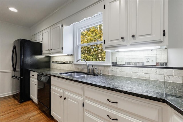 5004 Haralson Way SW, Lilburn, GA 30047 - kitchen featuring black appliances, dark stone counters, white cabinetry, crown molding, and light wood finished floors