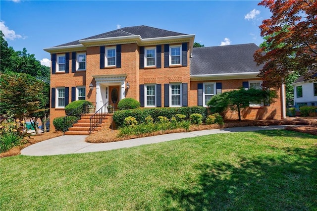 5004 Haralson Way SW, Lilburn, GA 30047 - georgian-style home featuring a front yard and brick siding