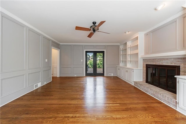 5004 Haralson Way SW, Lilburn, GA 30047 - unfurnished living room featuring a decorative wall, a ceiling fan, light wood-type flooring, a fireplace, and crown molding