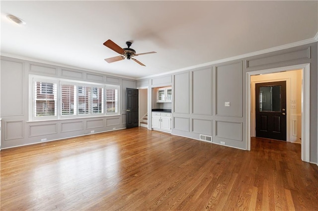 5004 Haralson Way SW, Lilburn, GA 30047 - unfurnished bedroom featuring a decorative wall, crown molding, wood finished floors, and ceiling fan