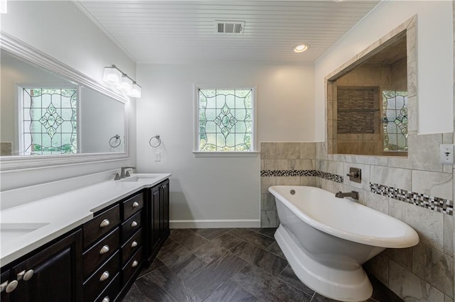 5004 Haralson Way SW, Lilburn, GA 30047 - bathroom with plenty of natural light, double vanity, a freestanding bath, tile walls, and a wainscoted wall