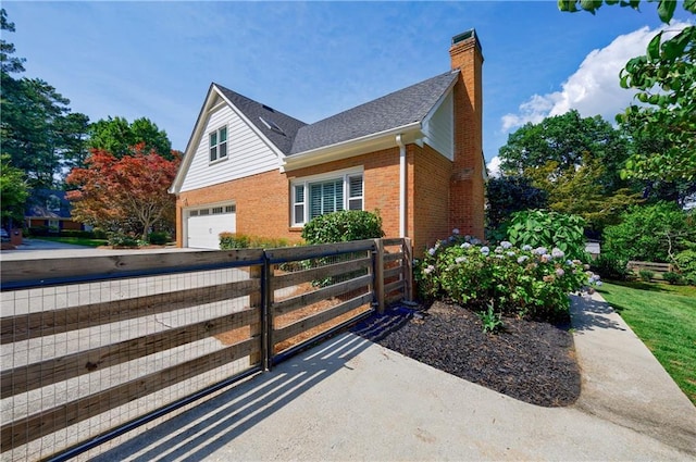 5004 Haralson Way SW, Lilburn, GA 30047 - view of side of home featuring brick siding, a chimney, an attached garage, and a gate