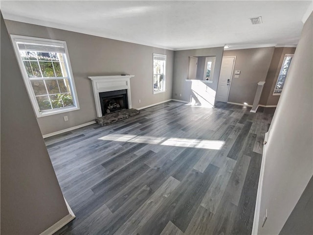 unfurnished living room with a healthy amount of sunlight and dark wood-type flooring