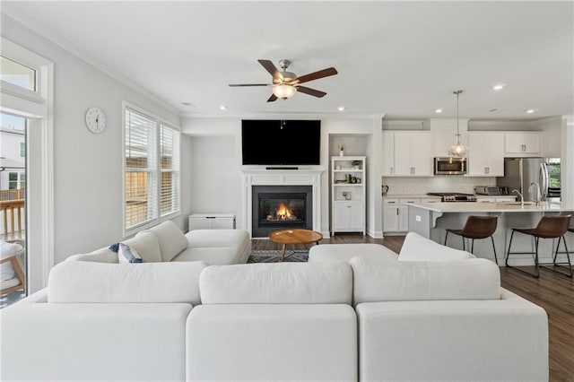 3440 Hardy St, Duluth, GA 30096 - living room featuring crown molding, a ceiling fan, dark wood finished floors, a glass covered fireplace, and recessed lighting