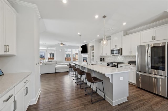 3440 Hardy St, Duluth, GA 30096 - kitchen featuring stainless steel appliances, open floor plan, a kitchen breakfast bar, a ceiling fan, and white cabinetry