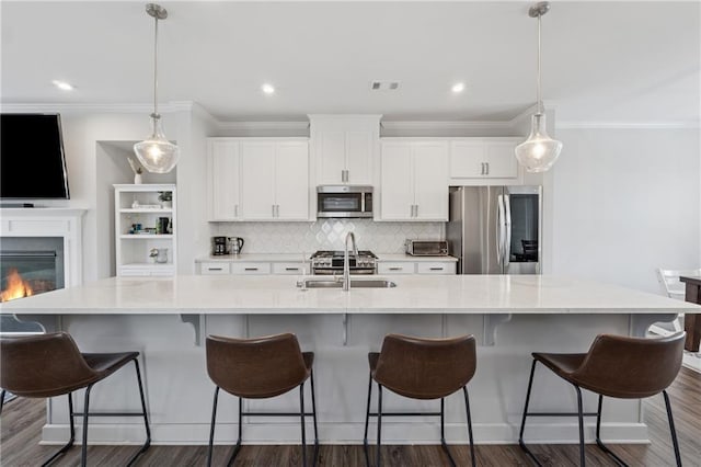 3440 Hardy St, Duluth, GA 30096 - kitchen featuring appliances with stainless steel finishes, a large island, white cabinets, crown molding, and dark wood finished floors