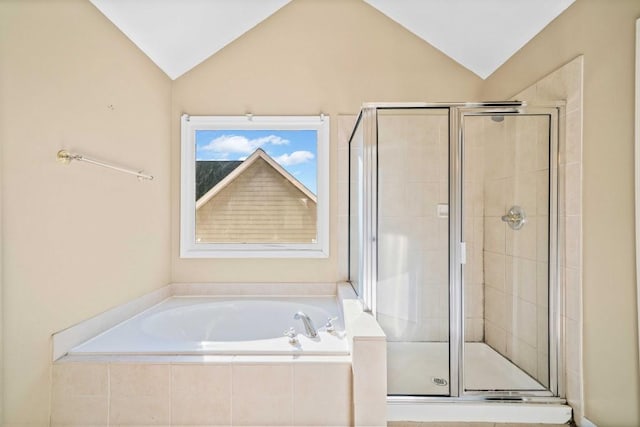 bathroom featuring a bath, a stall shower, and lofted ceiling