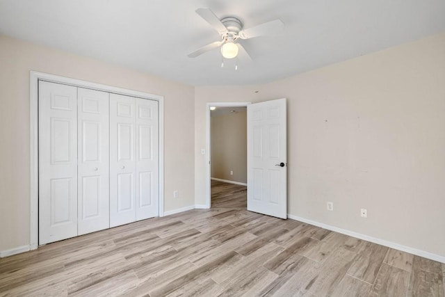 unfurnished bedroom featuring a closet, baseboards, a ceiling fan, and light wood finished floors