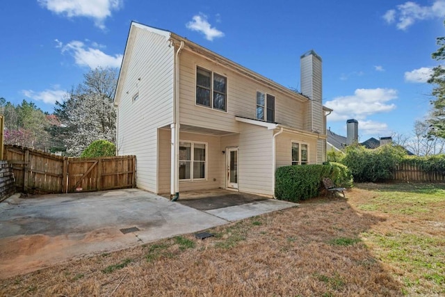 back of property featuring a patio, a chimney, and fence