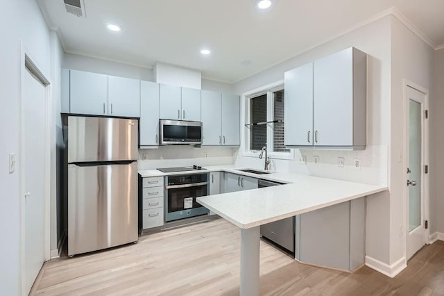 kitchen with ceiling fan, sink, stainless steel appliances, tasteful backsplash, and light wood-type flooring