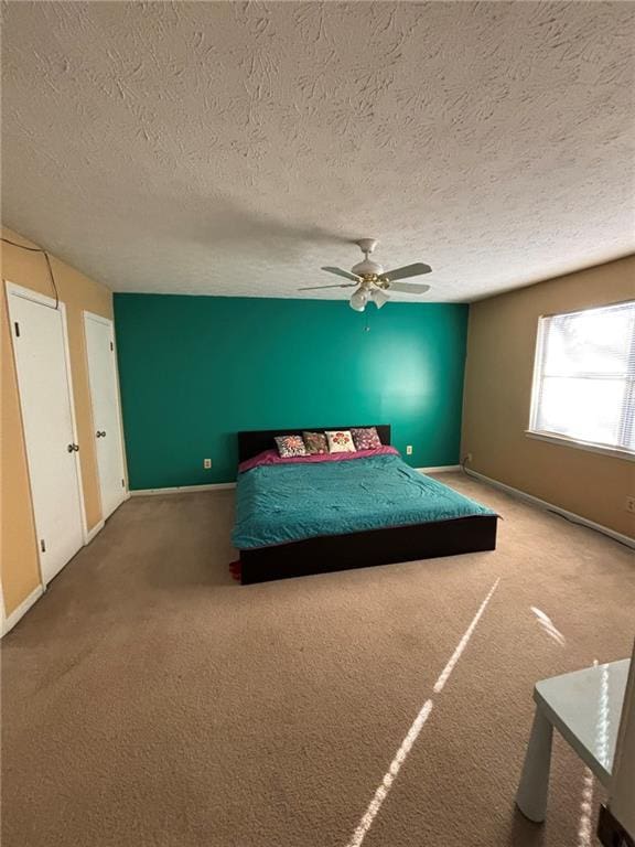 unfurnished bedroom with ceiling fan, carpet flooring, and a textured ceiling