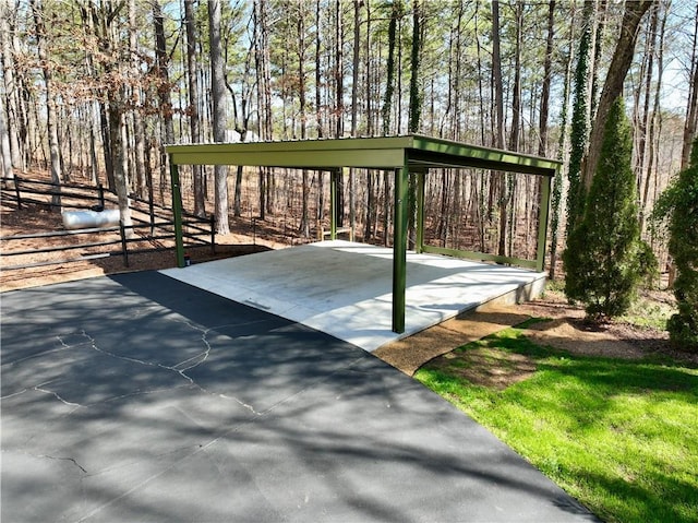 view of patio / terrace featuring basketball hoop and a detached carport