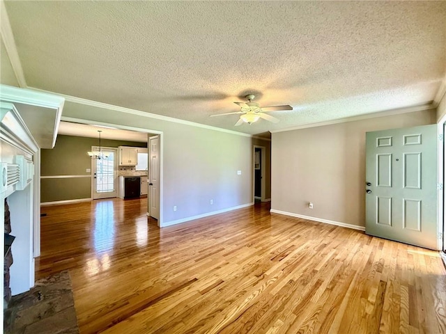 unfurnished living room featuring baseboards, light wood-style floors, a textured ceiling, crown molding, and ceiling fan with notable chandelier